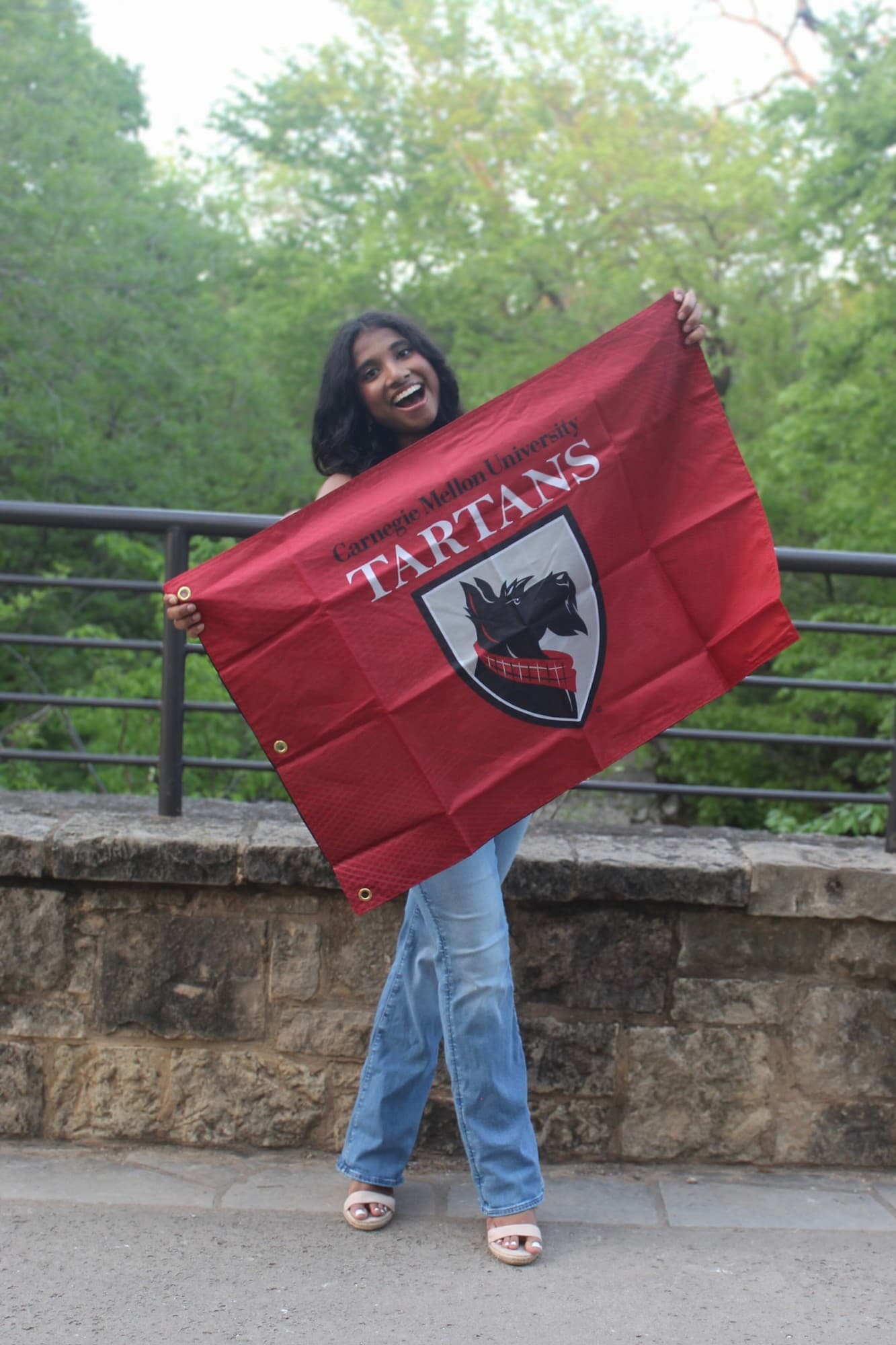 Isha Swaminathan holding a Carnegie Mellon Tartans flag